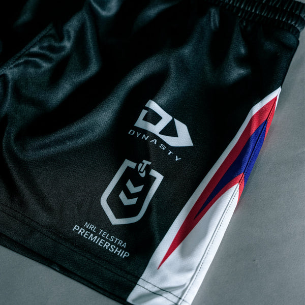 Black sports shorts with logos on a gray surface